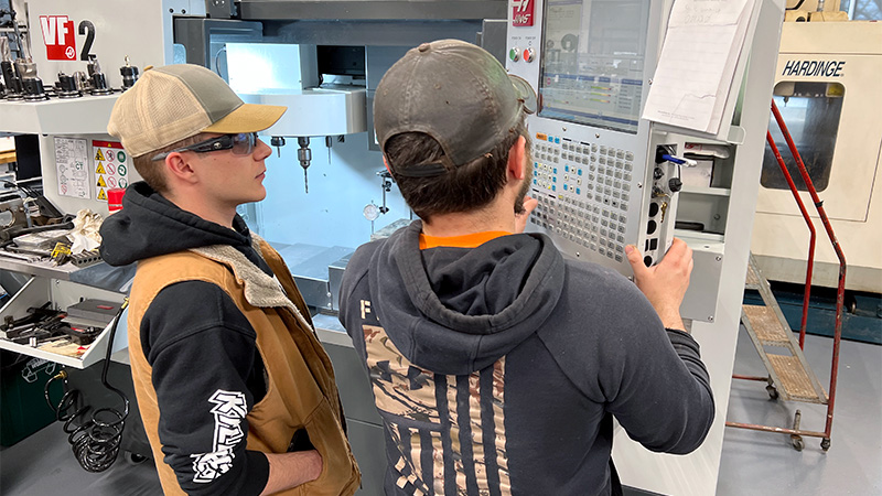 Photo of two male students with electronic equipment